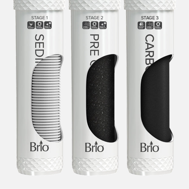 Three white cylindrical Brio water filter cartridges labeled as Stage 1 Sediment, Stage 2 Pre Carbon, and Stage 3 Carbon, each with a window showing different filter materials inside.